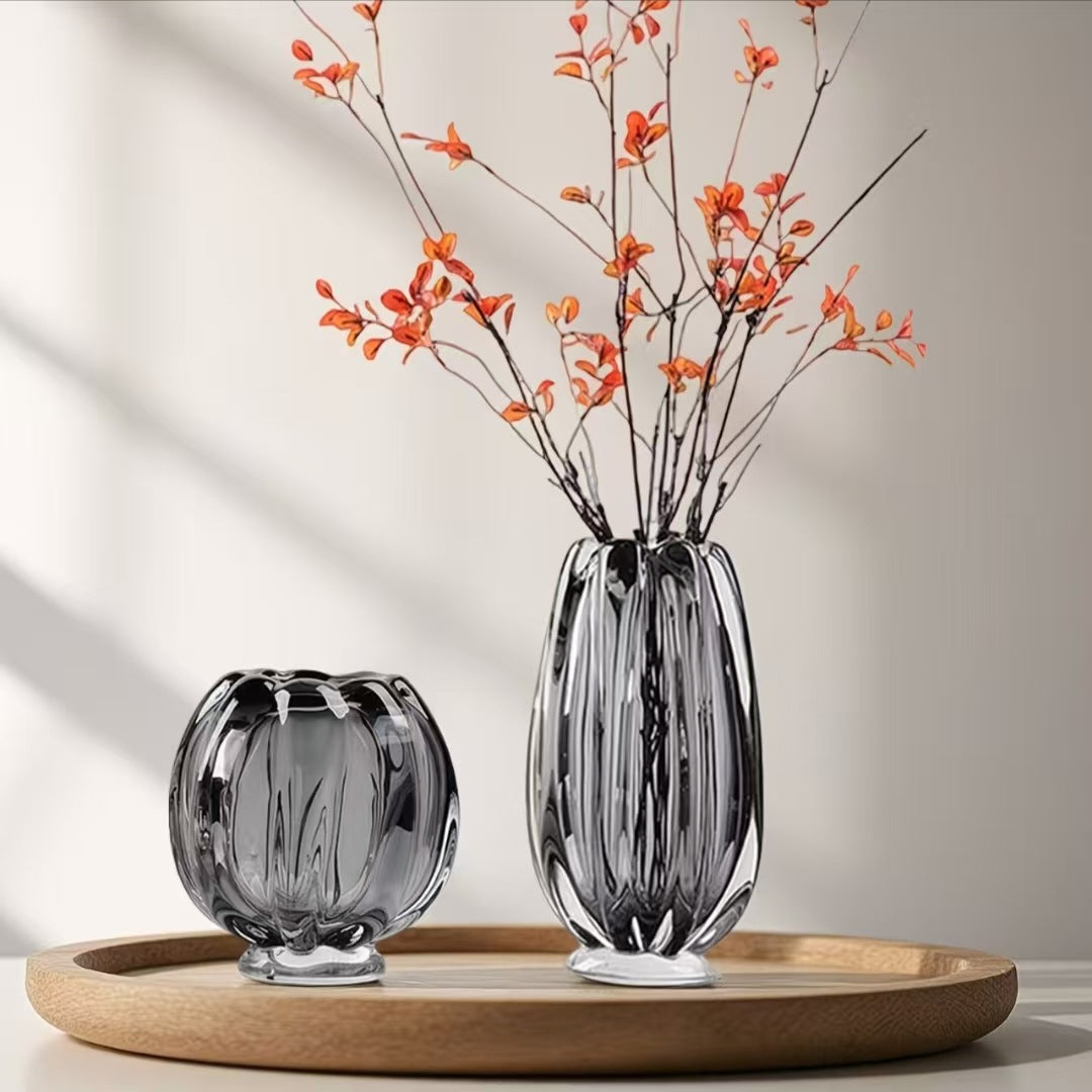 Stijlvolle glazen vazen in rookgrijs design, gecombineerd met decoratieve takken op een houten dienblad. Deze moderne vazen geven ieder interieur een luxe en sfeervolle uitstraling en passen perfect binnen een modern, minimalistisch of hotel-chique interieur.